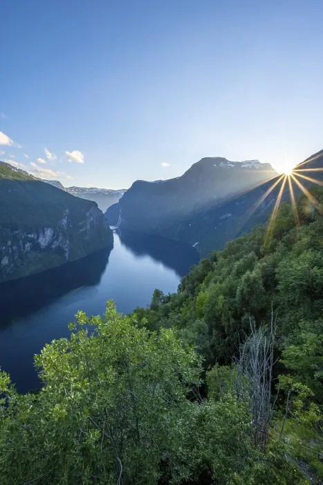 Gerahmter Druck : Die Sonne scheint über einem Berggrat. Gerahmter Druck : Die Sonne scheint über einem Berggrat.