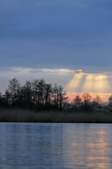 Gerahmter Druck : Sonnenschein durch Wolken über einem Fluss am Abend. Gerahmter Druck : Sonnenschein durch Wolken über einem Fluss am Abend.