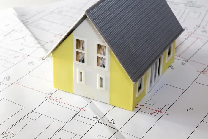 Gerahmter Druck : Symbolisches Bild eines Bauwerks: Modellhaus auf einem Bebauungsplan. Gerahmter Druck : Symbolisches Bild eines Bauwerks: Modellhaus auf einem Bebauungsplan.