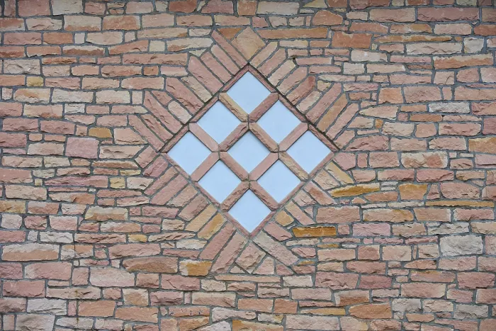 Gerahmter Druck : Symmetrische Steinbruchmauer mit einem fensterförmigen Diamantmuster.