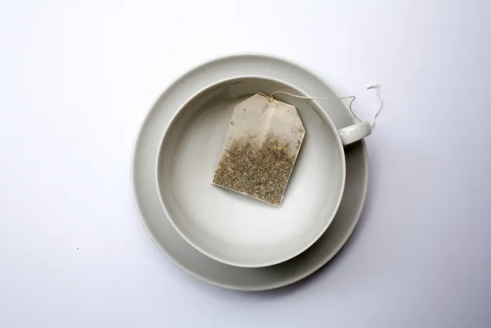 Gerahmter Druck : Ein Teebeutel in einem leeren Becher. Gerahmter Druck : Ein Teebeutel in einem leeren Becher.