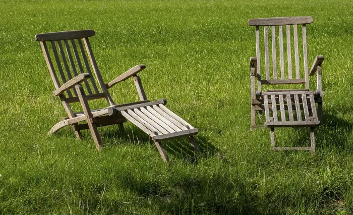 Gerahmter Druck : Zwei Teak-Deckstühle in einem Wiesengrund. Gerahmter Druck : Zwei Teak-Deckstühle in einem Wiesengrund.