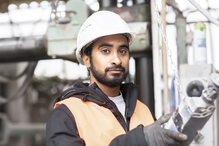 Gerahmter Druck : Techniker mit Bart und Helm arbeitet in einer Werkstatt. Gerahmter Druck : Techniker mit Bart und Helm arbeitet in einer Werkstatt.