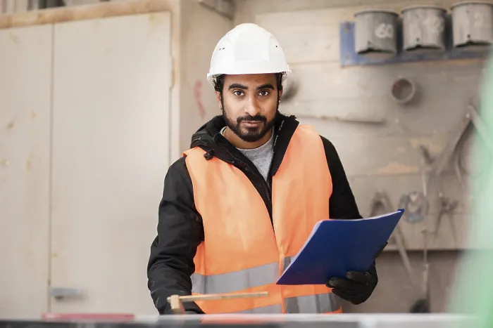 Gerahmter Druck : Techniker mit Bart und Helm arbeitet in einer Werkstatt. Gerahmter Druck : Techniker mit Bart und Helm arbeitet in einer Werkstatt.