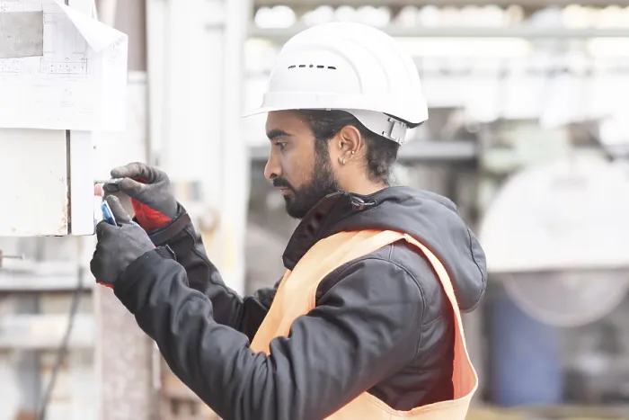 Gerahmter Druck : Techniker mit Bart und Helm arbeitet in einem Werkstatt. Gerahmter Druck : Techniker mit Bart und Helm arbeitet in einem Werkstatt.