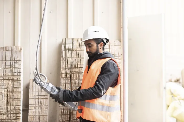 Gerahmter Druck : Techniker mit Bart und Helm arbeitet in einer Werkstatt. Gerahmter Druck : Techniker mit Bart und Helm arbeitet in einer Werkstatt.