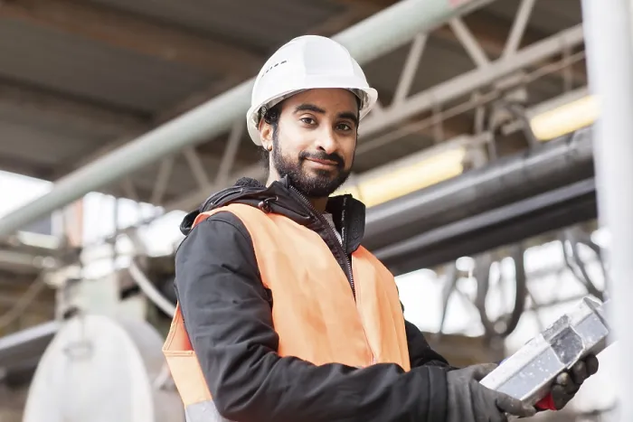 Gerahmter Druck : Techniker mit Bart und Helm arbeitet in einer Werkstatt. Gerahmter Druck : Techniker mit Bart und Helm arbeitet in einer Werkstatt.