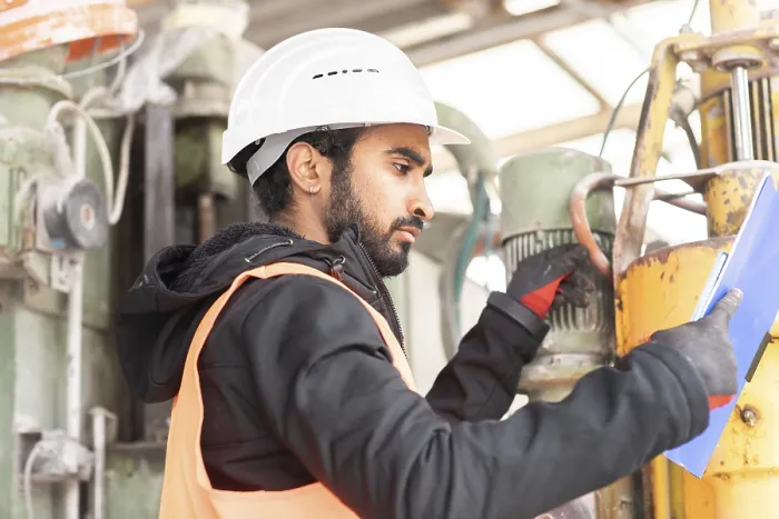 Gerahmter Druck : Techniker mit Bart und Helm arbeitet in einer Werkstatt. Gerahmter Druck : Techniker mit Bart und Helm arbeitet in einer Werkstatt.
