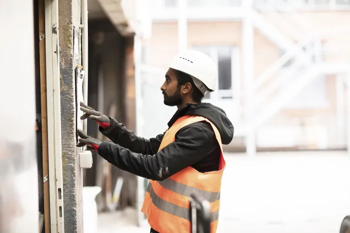Gerahmter Druck : Techniker mit Bart und Helm arbeitet in einer Werkstatt. Gerahmter Druck : Techniker mit Bart und Helm arbeitet in einer Werkstatt.