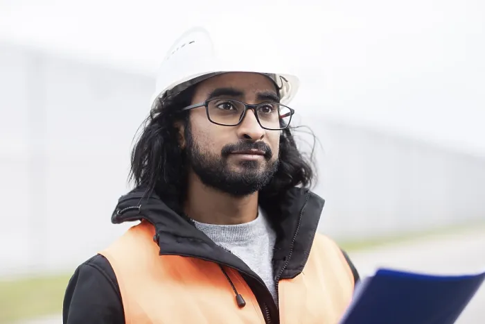 Gerahmter Druck : Techniker mit Bart und Helm arbeitet in einer Werkstatt. Gerahmter Druck : Techniker mit Bart und Helm arbeitet in einer Werkstatt.