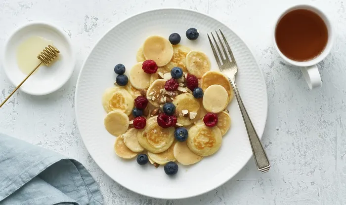 Gerahmter Druck : Frühstück für Kinder mit kleinen, dünnen Pfannkuchen und Crumpets auf einem weißen Tischtuch Gerahmter Druck : Frühstück für Kinder mit kleinen, dünnen Pfannkuchen und Crumpets auf einem weißen Tischtuch