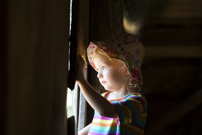 Gerahmter Druck : Kleinkind schaut aus einem Fenster. Gerahmter Druck : Kleinkind schaut aus einem Fenster.
