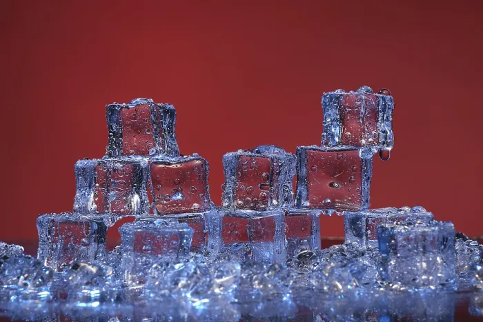 Gerahmter Druck : Transluzente kalte Eiswürfel auf einem roten Hintergrund.