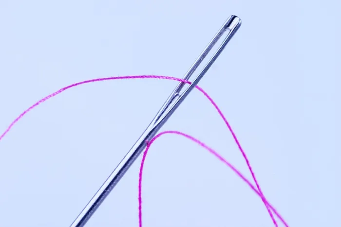 Gerahmter Druck : Faden mit Nadel. Gerahmter Druck : Faden mit Nadel.