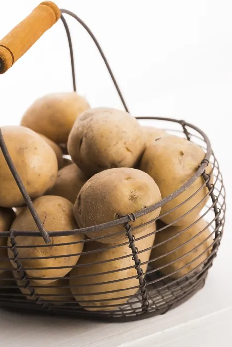 Gerahmter Druck : Ungekochte Kartoffeln in Drahtkorb.