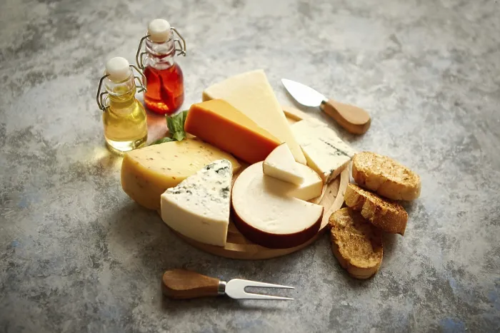 Gerahmter Druck : Verschiedene Arten von Käse auf einem rustikalen Holzteller. Gerahmter Druck : Verschiedene Arten von Käse auf einem rustikalen Holzteller.
