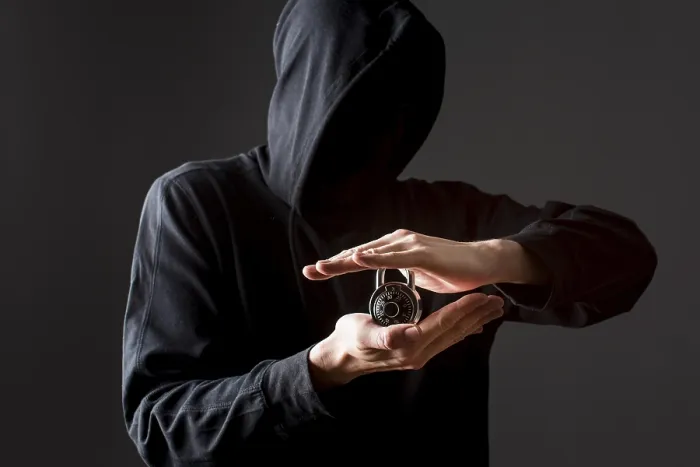 Gerahmter Druck : Vorderansicht Hacker hält Schloss. Gerahmter Druck : Vorderansicht Hacker hält Schloss.