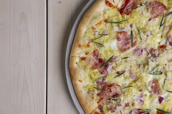 Gerahmter Druck : Blick von oben auf einen Teil einer Pizza mit Speckchips, Schinken, Käse und Rosmarin. Gerahmter Druck : Blick von oben auf einen Teil einer Pizza mit Speckchips, Schinken, Käse und Rosmarin.