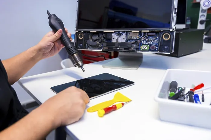 Gerahmter Druck : Seitenansicht eines nicht erkennbaren Technikers, der ein Computerkomponenten mit einem Schweißbrenner in einer Werkstatt repariert. Gerahmter Druck : Seitenansicht eines nicht erkennbaren Technikers, der ein Computerkomponenten mit einem Schweißbrenner in einer Werkstatt repariert.