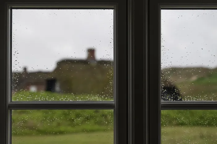 Gerahmter Druck : Blick durch Fensterscheiben mit Regentropfen, die sich zu Tropfen ballen.