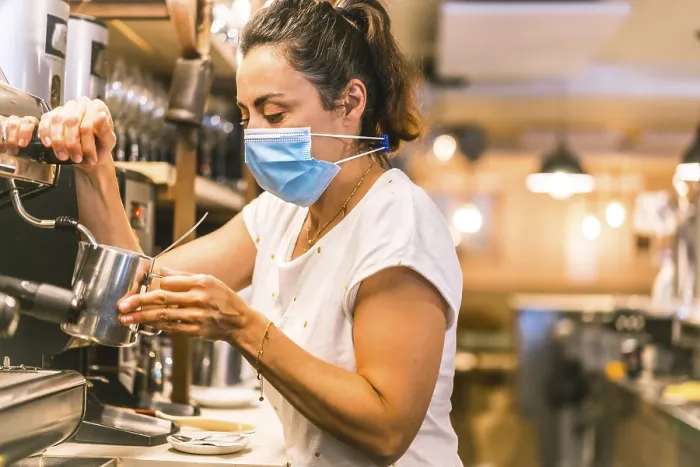 Gerahmter Druck : Eine Kellnerin mit einem Gesichtsmasken in einem Bar. Gerahmter Druck : Eine Kellnerin mit einem Gesichtsmasken in einem Bar.