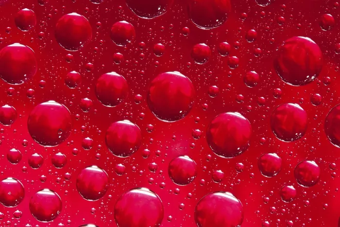 Gerahmter Druck : Viele Wassertröpfchen auf rotem Hintergrund.