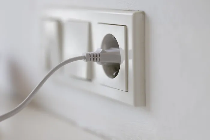 Gerahmter Druck : Weißer Stecker in einer Steckdose an der Wand. Gerahmter Druck : Weißer Stecker in einer Steckdose an der Wand.