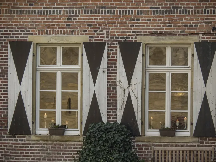 Gerahmter Druck : Zwei verputzte Fenster mit Läden an einer Backsteinmauer. Gerahmter Druck : Zwei verputzte Fenster mit Läden an einer Backsteinmauer.