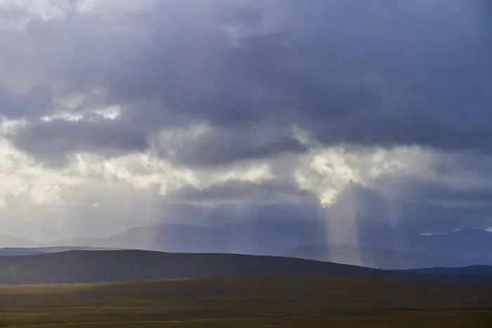 Gerahmter Druck : Landschaft mit weiten Hügeln und Sonnenstrahlen, die durch Wolken fallen Gerahmter Druck : Landschaft mit weiten Hügeln und Sonnenstrahlen, die durch Wolken fallen