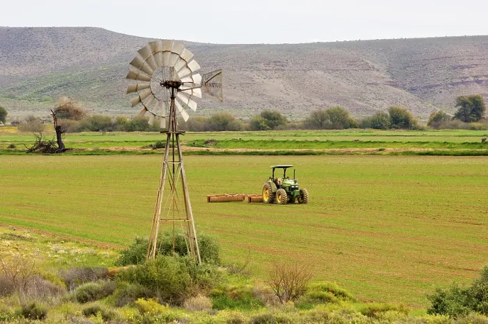 Gerahmter Druck : Windmühle eines Bewässerungspumpen und eines Tractors in einem Feld. Gerahmter Druck : Windmühle eines Bewässerungspumpen und eines Tractors in einem Feld.