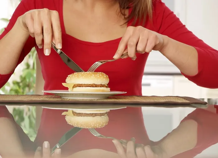 Gerahmter Druck : Die Frau isst einen Burger. Gerahmter Druck : Die Frau isst einen Burger.
