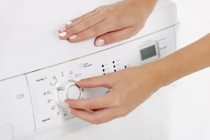 Gerahmter Druck : Frau programmiert Waschmaschine. Gerahmter Druck : Frau programmiert Waschmaschine.