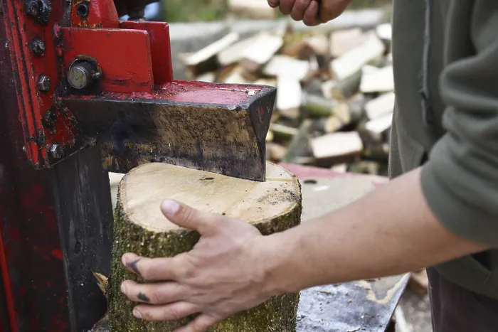 Gerahmter Druck : Arbeiter macht Holzfeuer mit einem Holzscheiter. Gerahmter Druck : Arbeiter macht Holzfeuer mit einem Holzscheiter.
