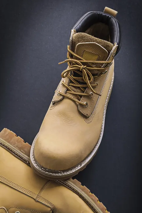 Gerahmter Druck : Arbeitsstiefel auf schwarzem Hintergrund. Gerahmter Druck : Arbeitsstiefel auf schwarzem Hintergrund.