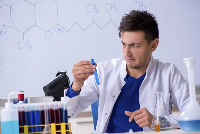 Gerahmter Druck : Junge Chemiker sitzt im Labor. Gerahmter Druck : Junge Chemiker sitzt im Labor.
