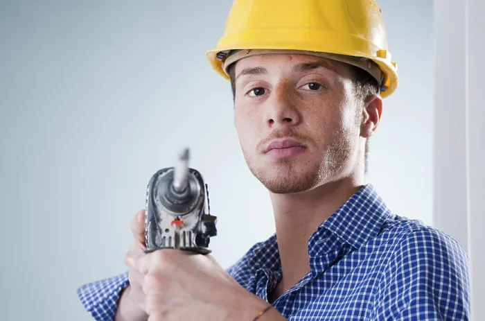 Gerahmter Druck : Jüngerer Handwerker mit Bohrmaschine. Gerahmter Druck : Jüngerer Handwerker mit Bohrmaschine.