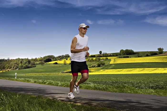 Gerahmter Druck : Ein junger Mann joggt durch die Felder. Gerahmter Druck : Ein junger Mann joggt durch die Felder.