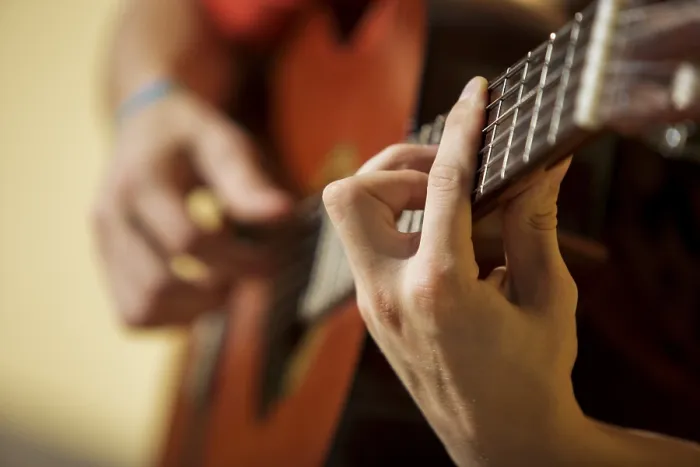 Gerahmter Druck : Jüngerer Mann spielt Gitarre, Saiteninstrument.