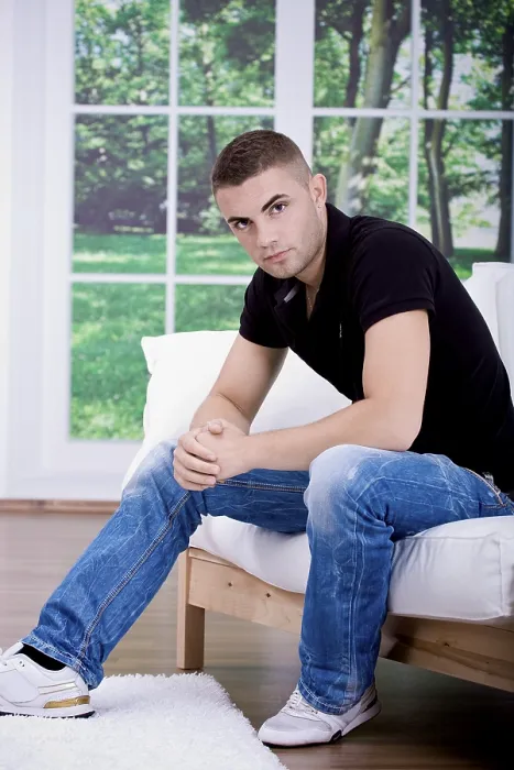 Gerahmter Druck : Jüngerer Mann sitzt auf einem Sofa. Gerahmter Druck : Jüngerer Mann sitzt auf einem Sofa.