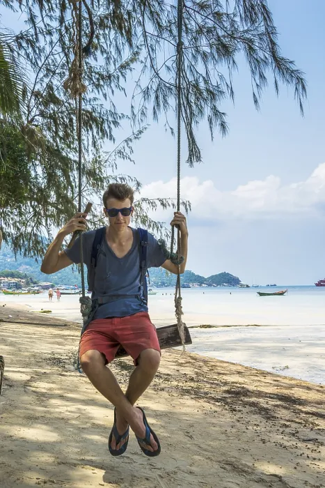Gerahmter Druck : Jüngerer Mann auf Schaukel, sandiger Strand. Gerahmter Druck : Jüngerer Mann auf Schaukel, sandiger Strand.
