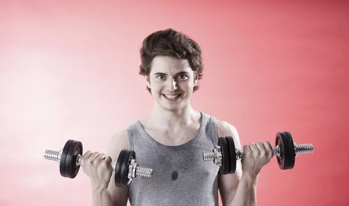 Gerahmter Druck : Jüngerer Mann benutzt Dumbbells während Krafttraining. Gerahmter Druck : Jüngerer Mann benutzt Dumbbells während Krafttraining.