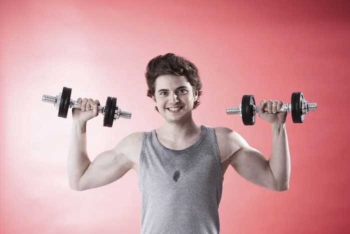 Gerahmter Druck : Jüngerer Mann benutzt Dumbbells während Krafttraining. Gerahmter Druck : Jüngerer Mann benutzt Dumbbells während Krafttraining.