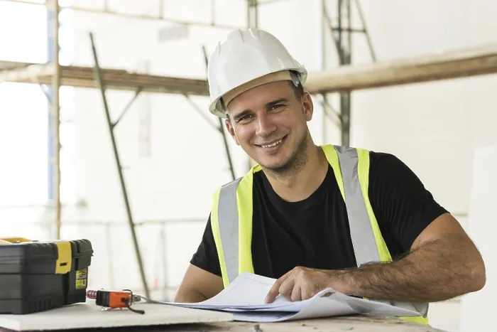 Gerahmter Druck : Jüngel ist Arbeiter, der Pläne überprüft, während er an einem Bauwerk arbeitet. Gerahmter Druck : Jüngel ist Arbeiter, der Pläne überprüft, während er an einem Bauwerk arbeitet.