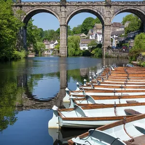 Ruderboote für Mietzwecke vor dem Eisenbahnviadukt über den Fluss Nidd in Knaresborough, Yorkshire, Vereinigtes Königreich. Ruderboote für Mietzwecke vor dem Eisenbahnviadukt über den Fluss Nidd in Knaresborough, Yorkshire, Vereinigtes Königreich.