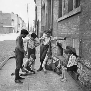 Un gruppo di ragazzi che giocano d'azzardo con i dadi sulla strada di Cincinnati, Ohio. Fotografia di Lewis Hine, c1908. Un gruppo di ragazzi che giocano d'azzardo con i dadi sulla strada di Cincinnati, Ohio. Fotografia di Lewis Hine, c1908.