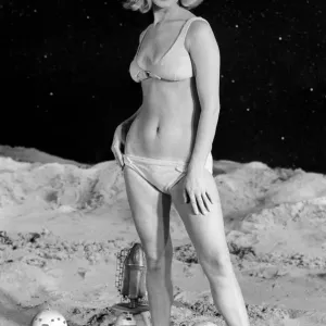 Model June Cooper in a bikini poses on a moon-themed backdrop, print