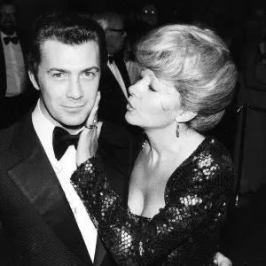 Lewis Collins Actor tiene su cara acariciada por Ingrid Pitt en la premiere de su película.