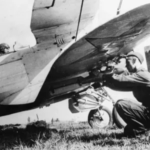 Print of a Soviet pilot at his aircraft controls with bombs attached Print of a Soviet pilot at his aircraft controls with bombs attached