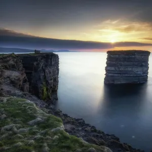 Paisaje costero con acantilados y farallón en el atardecer, Condado de Mayo, Irlanda. Paisaje costero con acantilados y farallón en el atardecer, Condado de Mayo, Irlanda.