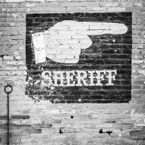 Escritura de sheriff en una pared de ladrillo antiguo.